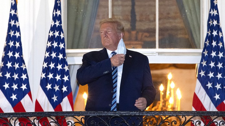 President Donald Trump removes his mask upon return to the White House from Walter Reed National Military Medical Center on October 05, 2020 in Washington, DC. Photo by Win McNamee/Getty Images.