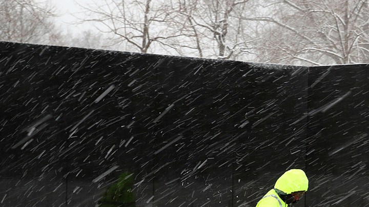 A U.S. Park Service worker spreads salt along walk way at the Vietnam War Memorial, on February 20, 2019 in Washington, DC. Photo by Mark Wilson/Getty Images