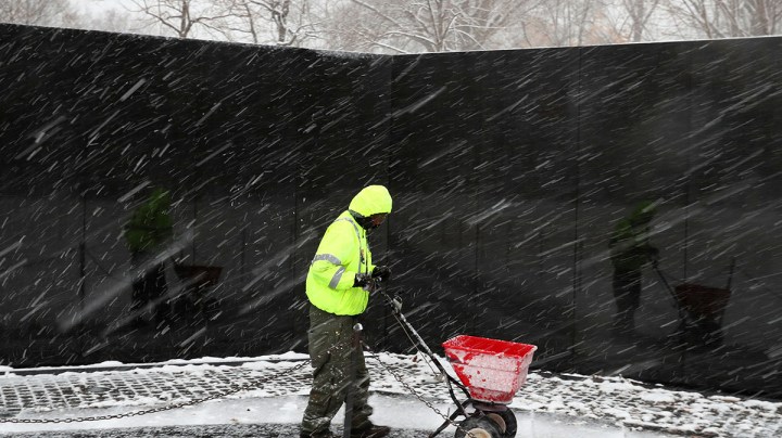 A U.S. Park Service worker spreads salt along walk way at the Vietnam War Memorial, on February 20, 2019 in Washington, DC. Photo by Mark Wilson/Getty Images
