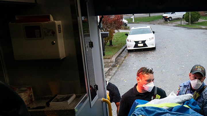 Firefighters and paramedics with Anne Arundel County Fire Department load a patient into an ambulance while responding to a 911 emergency call on November 11, 2020 in Glen Burnie, Maryland. Photo by Alex Edelman/Getty Images