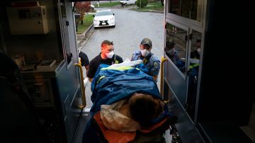 Firefighters and paramedics with Anne Arundel County Fire Department load a patient into an ambulance while responding to a 911 emergency call on November 11, 2020 in Glen Burnie, Maryland. Photo by Alex Edelman/Getty Images