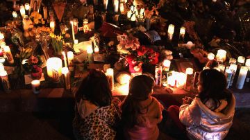 U.S. born children of Mexican immigrants gaze at a makeshift shrine at the University Medical Center, for those killed and wounded during an attack on U.S. Rep. Gabrielle Giffords (D-AZ) on January 9, 2011 in Tucson, Arizona. Photo by John Moore/Getty Images