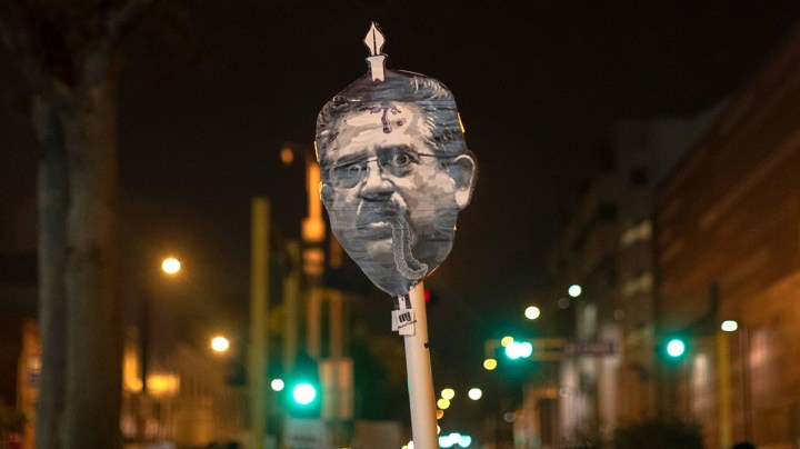 Protesters hold posters with images depicting Peru's newly sworn-in president Manuel Merino on November 14, 2020 in Lima, Peru. Photo by Beto Baron/Getty Images