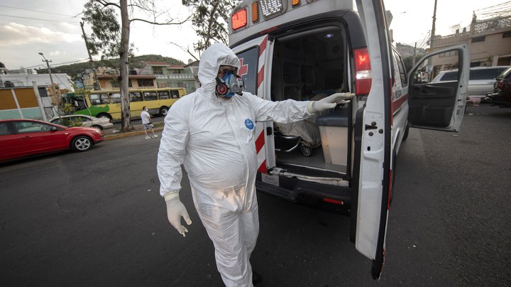 A paramedic of the Mexican Red Cross closes the doors of an ambulance to transport a person with possible COVID-19 during the answer to an emergency call on June 19, 2020 in Mexico City, Mexico. Photo by Hector Vivas/Getty Images