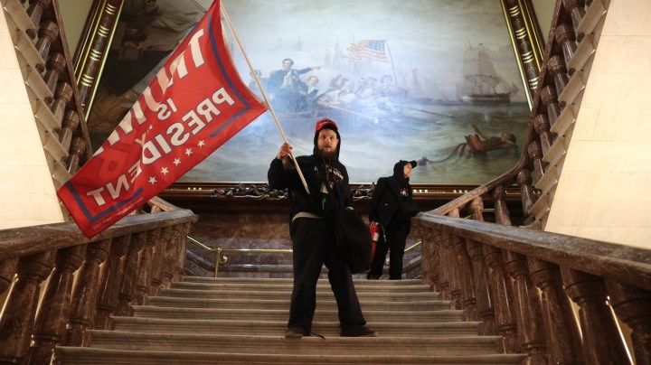 A protester holds a Trump flag inside the US Capitol Building near the Senate Chamber on January 06, 2021 in Washington, DC. Photo by Win McNamee/Getty Images