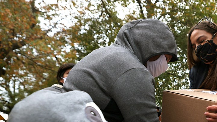 Rep. Alexandria Ocasio-Cortez (D-NY) places a box of food on a cart during a food distribution event on October 27, 2020 in New York City. (Photo by Michael M. Santiago/Getty Images)