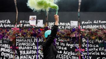 A woman, takes part during a performance of Feminist groups, to write names of victims of femicide and place flowers in protest against gender violence, as part of the protests of International Women's Day at the National Palace on March 7, 2021 in Mexico City, Mexico. Photo credit Luis Barron / Eyepix Group/Barcroft Media via Getty Images