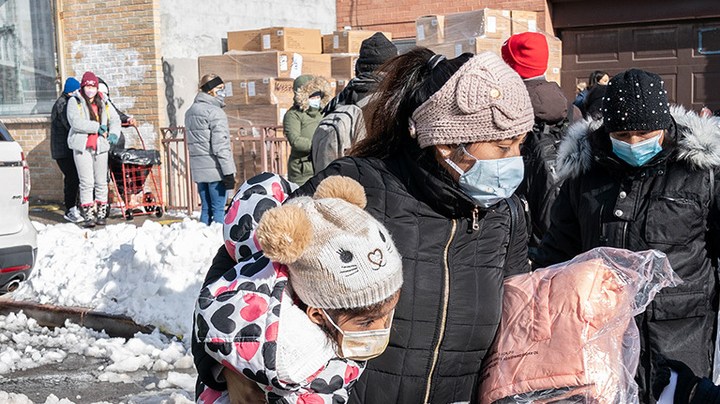 A mother and 2 kids received coats and toys during New York Cares volunteers in partnership with Together We Can local non-profit organization and Assemblywoman Catalina Cruz distribution of holidays toys and winter coats in Corona, Queens. Photo by Lev Radin/Pacific Press/LightRocket via Getty Images