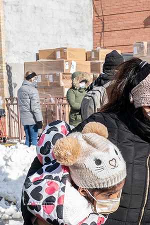 A mother and 2 kids received coats and toys during New York Cares volunteers in partnership with Together We Can local non-profit organization and Assemblywoman Catalina Cruz distribution of holidays toys and winter coats in Corona, Queens. Photo by Lev Radin/Pacific Press/LightRocket via Getty Images