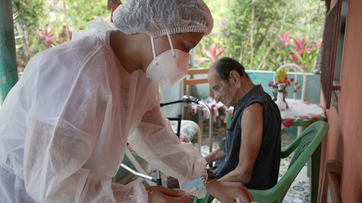 Dr Ramos visits Jose Vieira de Andrade (r) at home as part of the vaccination campaign for people over 80. Photo: Morena Perez Joachin/dpa Photo by Morena Perez Joachin/picture alliance via Getty Images