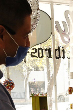 Janie Isidoro, owner of My Corazon, a Chicano business in downtown Hanford, CA helps Carlos Garcia, left. Al Seib / Los Angeles Times