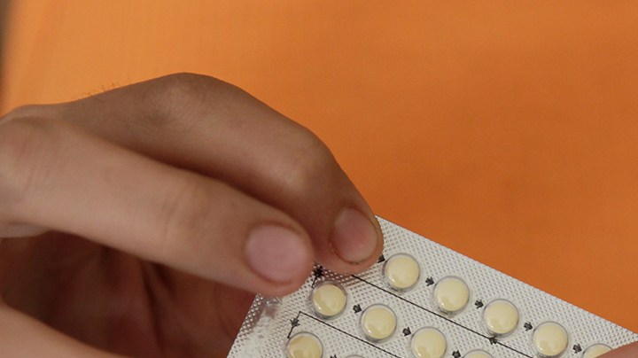 Woman's hands holding birth control pills. Photo Courtesy of Getty Images