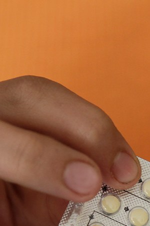 Woman's hands holding birth control pills. Photo Courtesy of Getty Images
