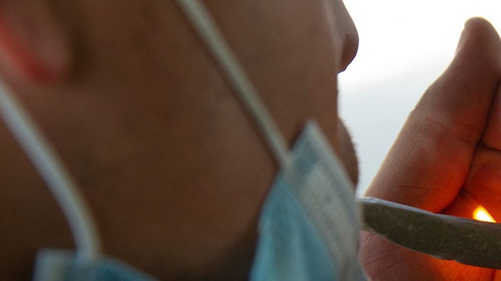 A man smokes a joint at the esplanade of the Estela de Luz monument in Mexico City, on March 10, 2021. Photo by CLAUDIO CRUZ/AFP via Getty Images