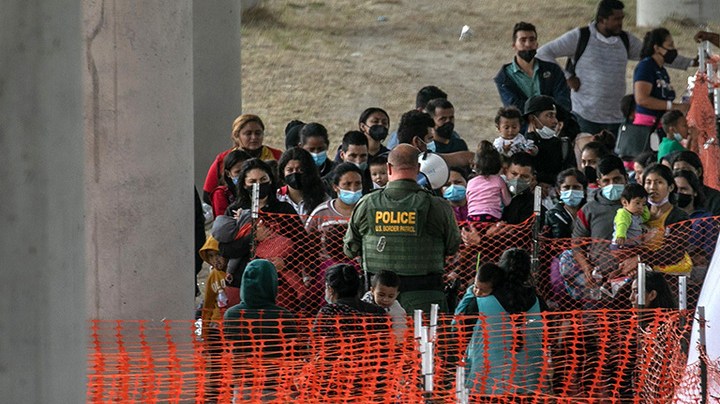 Asylum seekers listen to instructions at an outdoor U.S. Border Patrol processing center under the Anzalduas International Bridge after crossing the Rio Grande from Mexico on March 23, 2021 near Mission, Texas. Photo by John Moore/Getty Images