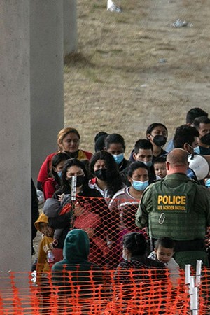 Asylum seekers listen to instructions at an outdoor U.S. Border Patrol processing center under the Anzalduas International Bridge after crossing the Rio Grande from Mexico on March 23, 2021 near Mission, Texas. Photo by John Moore/Getty Images