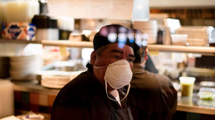 A cook at Arnaldo Richards' Picos wears gloves and a mask while cooking orders amid the coronavirus pandemic May 1, 2020 in Houston, Texas. Photo by MARK FELIX/AFP /AFP via Getty Images