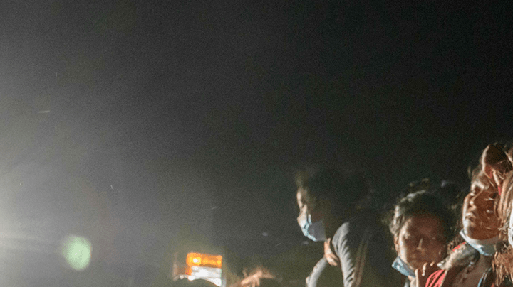 Women and children immigrants who arrived illegally across the Rio Grande river from Mexico rest on March 27, 2021 at a makeshift processing checkpoint before being detained at a holding facility by border patrol agents in the border city of Roma. Photo by Ed JONES / AFP.