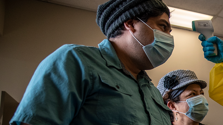 Kelly Russell takes the temperature of a patient at a vaccination site at a senior center on March 29, 2021 in San Antonio, Texas. Photo by Sergio Flores/Getty Images