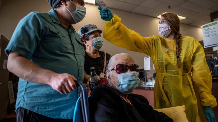 Kelly Russell takes the temperature of a patient at a vaccination site at a senior center on March 29, 2021 in San Antonio, Texas. Photo by Sergio Flores/Getty Images