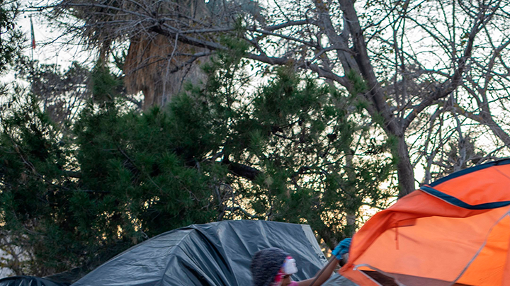 Girls carry a tent to across the campsite of asylum seekers near Bridge of the Americas at Chamizal Park on December 19, 2019 in Ciudad Juarez, Mexico. Photo by PAUL RATJE/AFP via Getty Images