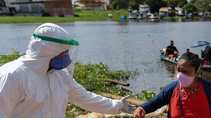 Health professionals help patients with symptoms of the new coronavirus brought on a boat ambulance from Vila Amazonia community upon their arrival in Parintins, Amazonas state, Brazil, on June 27, 2020. Photo by MICHAEL DANTAS/AFP via Getty Images