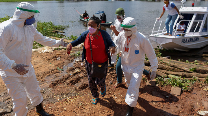 Health professionals help patients with symptoms of the new coronavirus brought on a boat ambulance from Vila Amazonia community upon their arrival in Parintins, Amazonas state, Brazil, on June 27, 2020. Photo by MICHAEL DANTAS/AFP via Getty Images