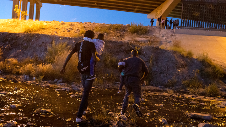 Two men with son in their arms, cross the Rio Bravo to surrender to the authorities with the intention of seeking political asylum in the United States, from Ciudad Juarez, in the Mexican state of Chihuahua, to El Paso, in the US state of Texas, on May 11, 2021. Photo by David Peinado/NurPhoto via Getty Images