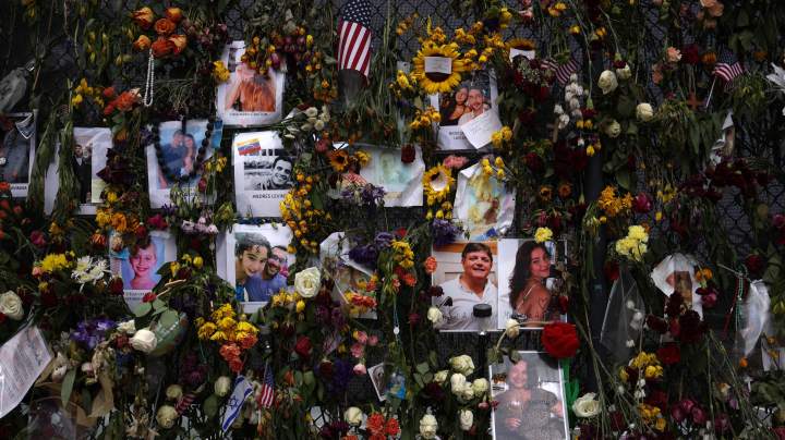 Signs and flowers hang on the memorial site of the collapsed 12-story Champlain Towers South condo building on July 10, 2021 in Surfside, Florida. With the death toll currently at 86 people, search and rescue personnel continue their recovery efforts as more grow concerned about the air quality in Surfside. Photo by Anna Moneymaker/Getty Images