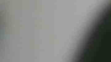 Unrecognizable black woman uses smart phone while sitting in chair in living room