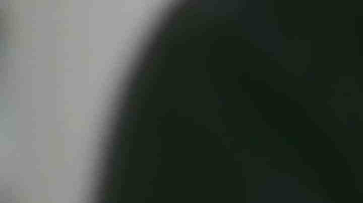 Unrecognizable black woman uses smart phone while sitting in chair in living room