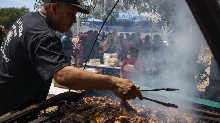 Pastor Marco Antonio Muniz cooks chicken for Haitian migrants in the Parque Ecologico Braulio Fernandez in Ciudad Acuna, Coahuila state, Mexico on September 22, 2021. - Mexican President Andres Manuel Lopez Obrador appealed to the United States on September 22 to take urgent action to tackle the migrant crisis reverberating across the Americas. Tens of thousands of migrants, many of them Haitians previously living in South America, have arrived in recent weeks in Mexico hoping to enter the United States. (Photo by PAUL RATJE / AFP)