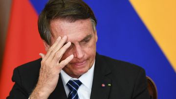 TOPSHOT - Brazilian President Jair Bolsonaro gestures during the signing of agreements with his Colombian counterpart Ivan Duque (out of frame) at Planalto Palace in Brasilia, on October 19, 2021. - Duque is on 2-day official visit to Brazil.