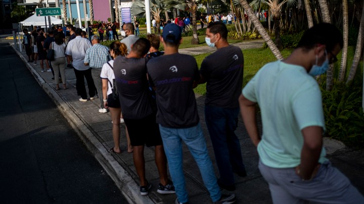 People line up outside the Puerto Rico Convention Center for the first mass Covid-19 vaccination event in San Juan, Puerto Rico on March 31, 2021. (Photo by Ricardo ARDUENGO / AFP) (Photo by RICARDO ARDUENGO/AFP via Getty Images)