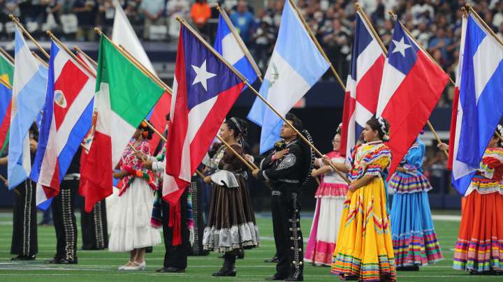 ARLINGTON, TEXAS - OCTOBER 10: Flags are displayed during the national anthem in honor of Hispanic Heritage Month before the game between the Dallas Cowboys and New York Giants at AT&T Stadium on October 10, 2021 in Arlington, Texas.