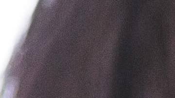 Midsection of working mother using technologies while daughter sitting in background at dining table