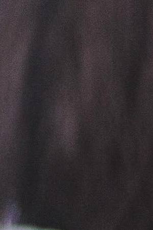 Midsection of working mother using technologies while daughter sitting in background at dining table