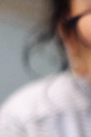 Low Angle View Of Woman Using Phone While Lying On Bed