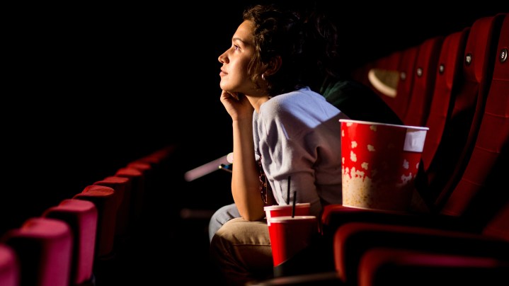 Young woman enjoying watching movie at the cinema