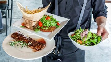 Miami, Florida, Brickell, Baires Grill, Argentinian restaurant, waiter serving food wearing protective face mask. (Photo by: Jeffrey Greenberg/UCG/Universal Images Group via Getty Images)
