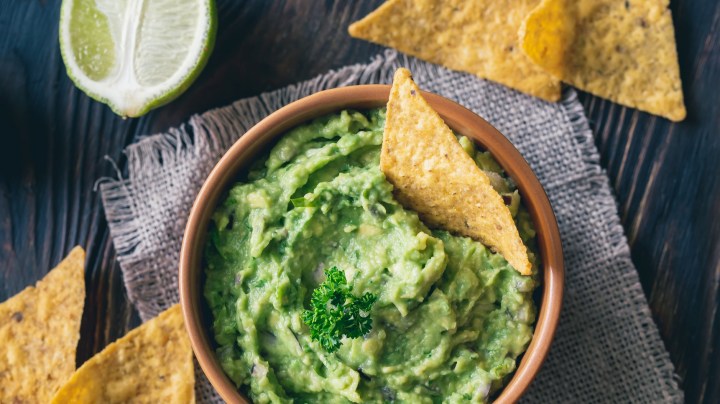 Bowl of guacamole with tortilla chips - stock photo