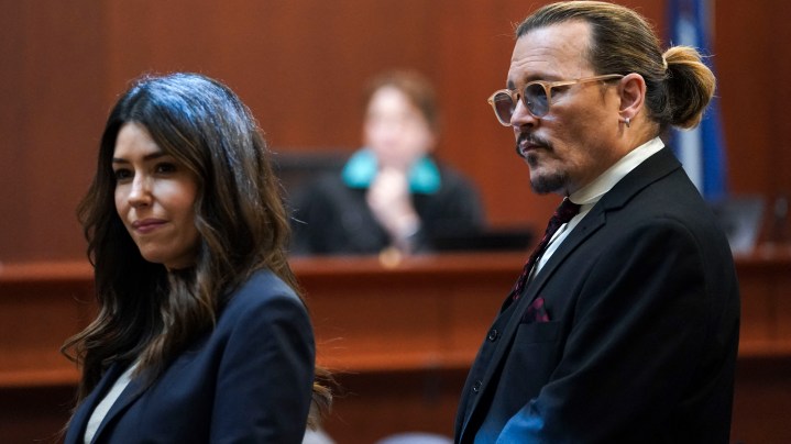 US actor Johnny Depp stands next to his lawyer Camille Vasquez after a break in the defamation trial against ex-wife Amber Heard at the Fairfax County Circuit Courthouse in Fairfax, Virginia, on May 18, 2022. - Depp is suing ex-wife Amber Heard for libel after she wrote an op-ed piece in The Washington Post in 2018 referring to herself as a public figure representing domestic abuse. (Photo by KEVIN LAMARQUE / POOL / AFP) (Photo by KEVIN LAMARQUE/POOL/AFP via Getty Images)