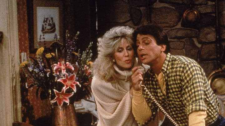 Actor Tony Danza eavesdrops as Judith Light speaks on the telephone, in a still from the TV series, 'Who's The Boss,' circa 1986. (Photo by ABC Television/Fotos International/Getty Images)