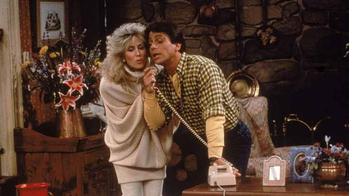 Actor Tony Danza eavesdrops as Judith Light speaks on the telephone, in a still from the TV series, 'Who's The Boss,' circa 1986. (Photo by ABC Television/Fotos International/Getty Images)