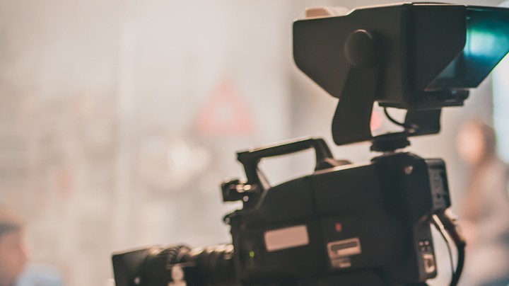 Behind the scene. Actor in front of the camera on the film set in film studio. Group movie scene