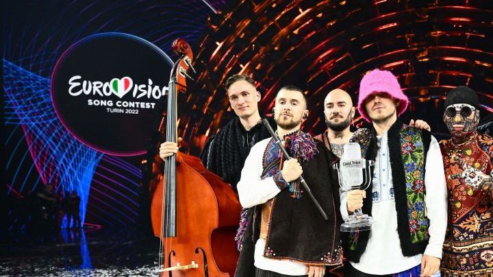 TOPSHOT - Members of the band "Kalush Orchestra" pose onstage with the winner's trophy and Ukraine's flags after winning on behalf of Ukraine the Eurovision Song contest 2022 on May 14, 2022 at the Pala Alpitour venue in Turin. (Photo by Marco BERTORELLO / AFP) (Photo by MARCO BERTORELLO/AFP via Getty Images)