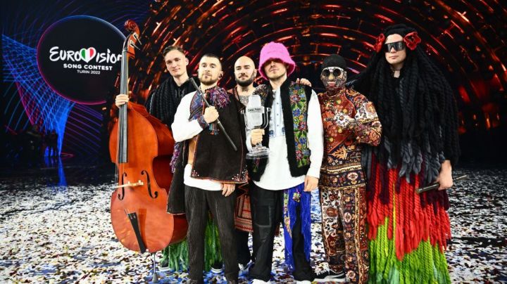 TOPSHOT - Members of the band "Kalush Orchestra" pose onstage with the winner's trophy and Ukraine's flags after winning on behalf of Ukraine the Eurovision Song contest 2022 on May 14, 2022 at the Pala Alpitour venue in Turin. (Photo by Marco BERTORELLO / AFP) (Photo by MARCO BERTORELLO/AFP via Getty Images)