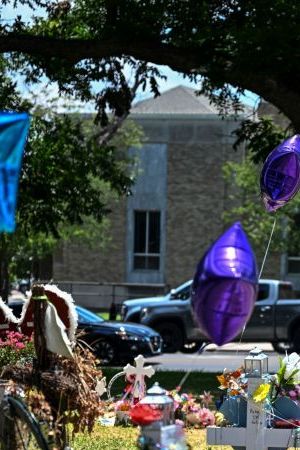 People visit a makeshift memorial to the victims of a shooting at Robb Elementary School outside the Uvalde County Courthouse in Uvalde, Texas, on June 30, 2022. - Nineteen young children and two teachers were killed when a teenage gunman went on a rampage at Robb Elementary on May 24 in America's worst school shooting in a decade. (Photo by CHANDAN KHANNA / AFP) (Photo by CHANDAN KHANNA/AFP via Getty Images)