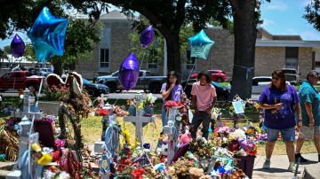 People visit a makeshift memorial to the victims of a shooting at Robb Elementary School outside the Uvalde County Courthouse in Uvalde, Texas, on June 30, 2022. - Nineteen young children and two teachers were killed when a teenage gunman went on a rampage at Robb Elementary on May 24 in America's worst school shooting in a decade. (Photo by CHANDAN KHANNA / AFP) (Photo by CHANDAN KHANNA/AFP via Getty Images)