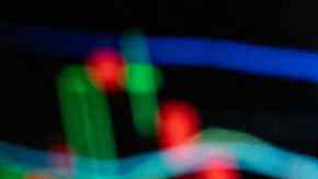 CHINA - 2021/12/09: In this photo illustration the American comic book publisher company DC Comics logo seen displayed on a smartphone with an economic stock exchange index graph in the background. (Photo Illustration by Budrul Chukrut/SOPA Images/LightRocket via Getty Images)